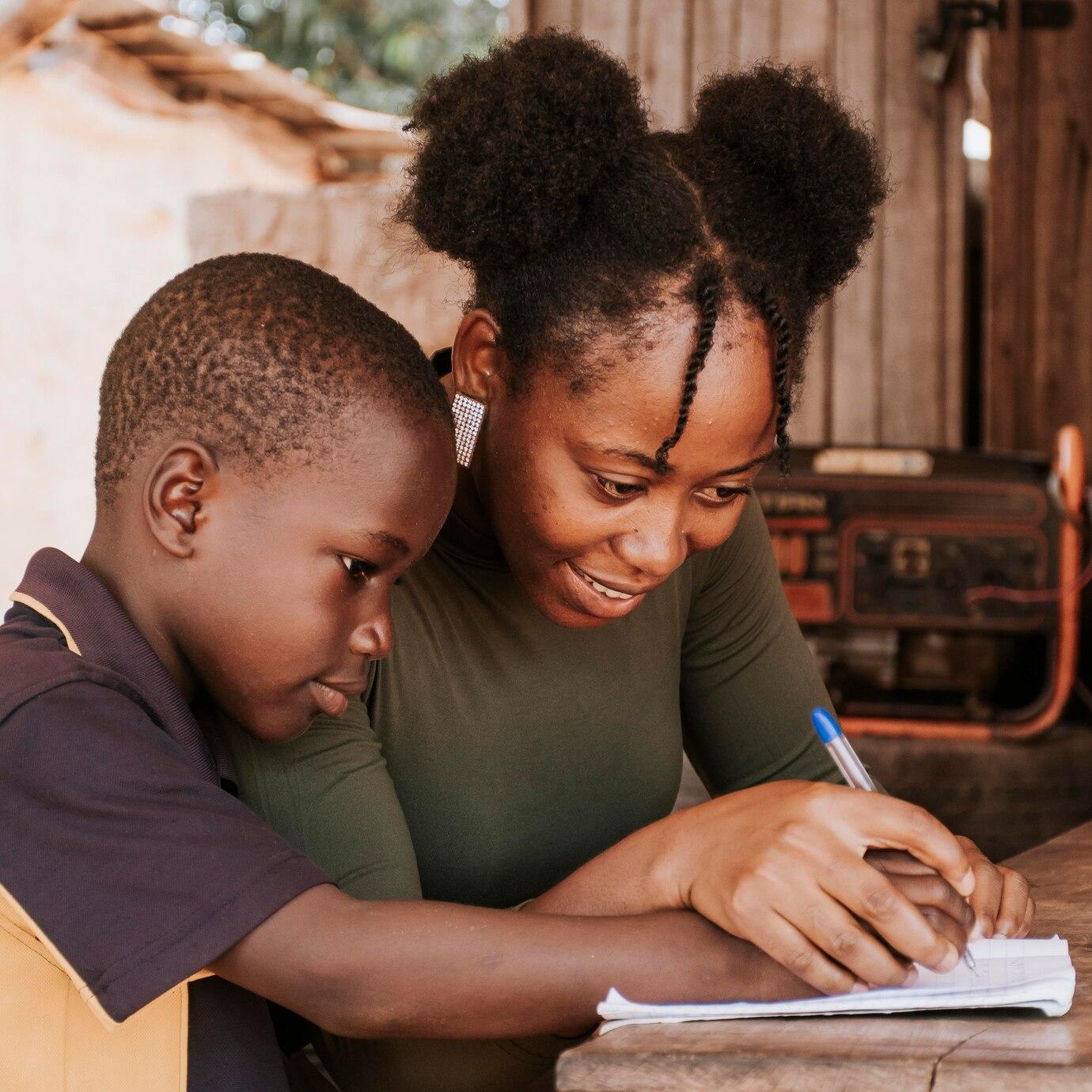 Parent/mère aidant son enfant à faire le devoir